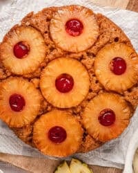 Overhead view of a pineapple upside down cake on a parchment-lined cutting board.