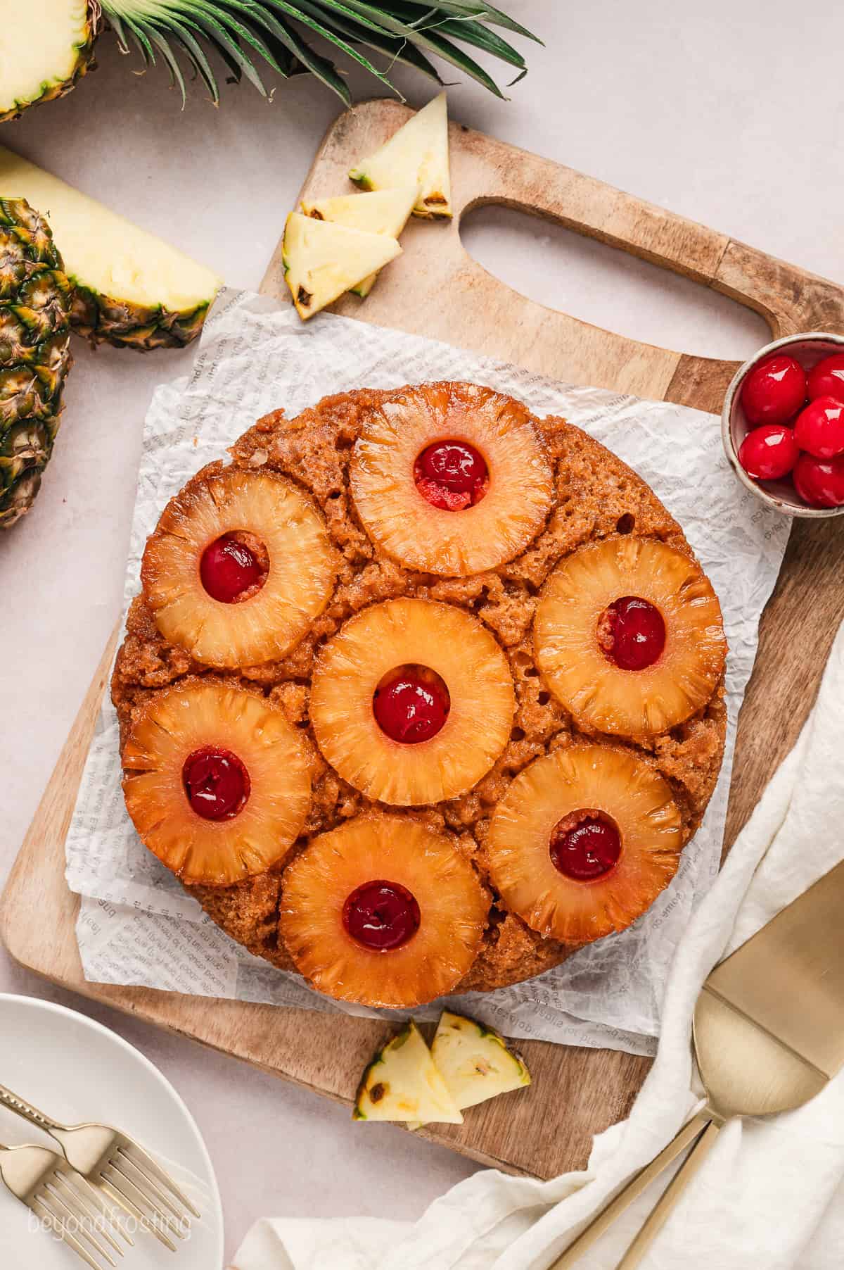 Overhead view of a pineapple upside down cake on a parchment-lined cutting board.