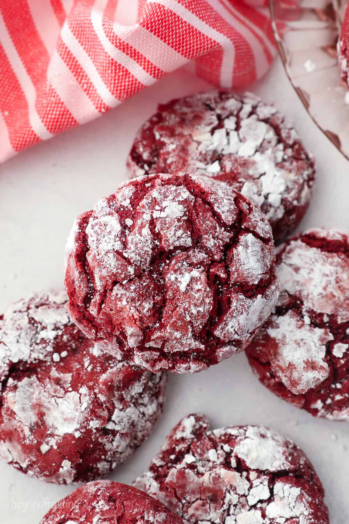 Overhead view of red velvet cake mix cookies scattered on a countertop.