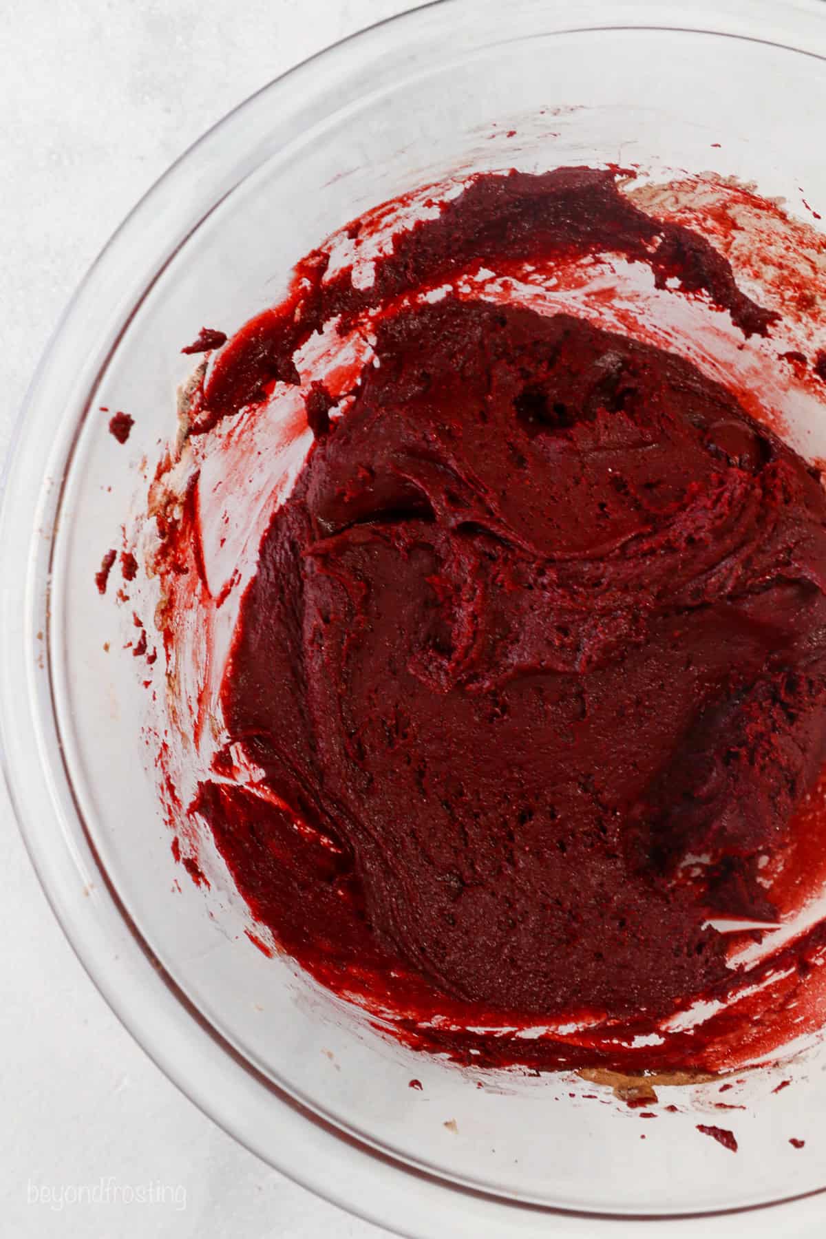 Red velvet cake mix cookie dough in a glass bowl.