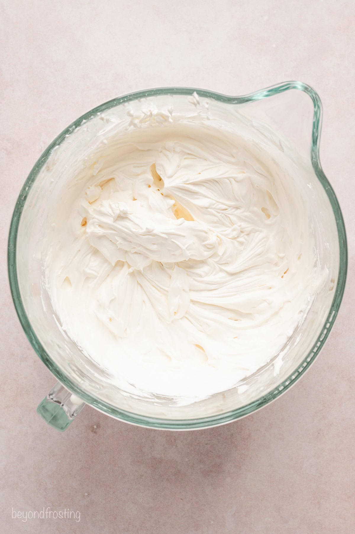 Whipped cream cheese frosting in a glass bowl.