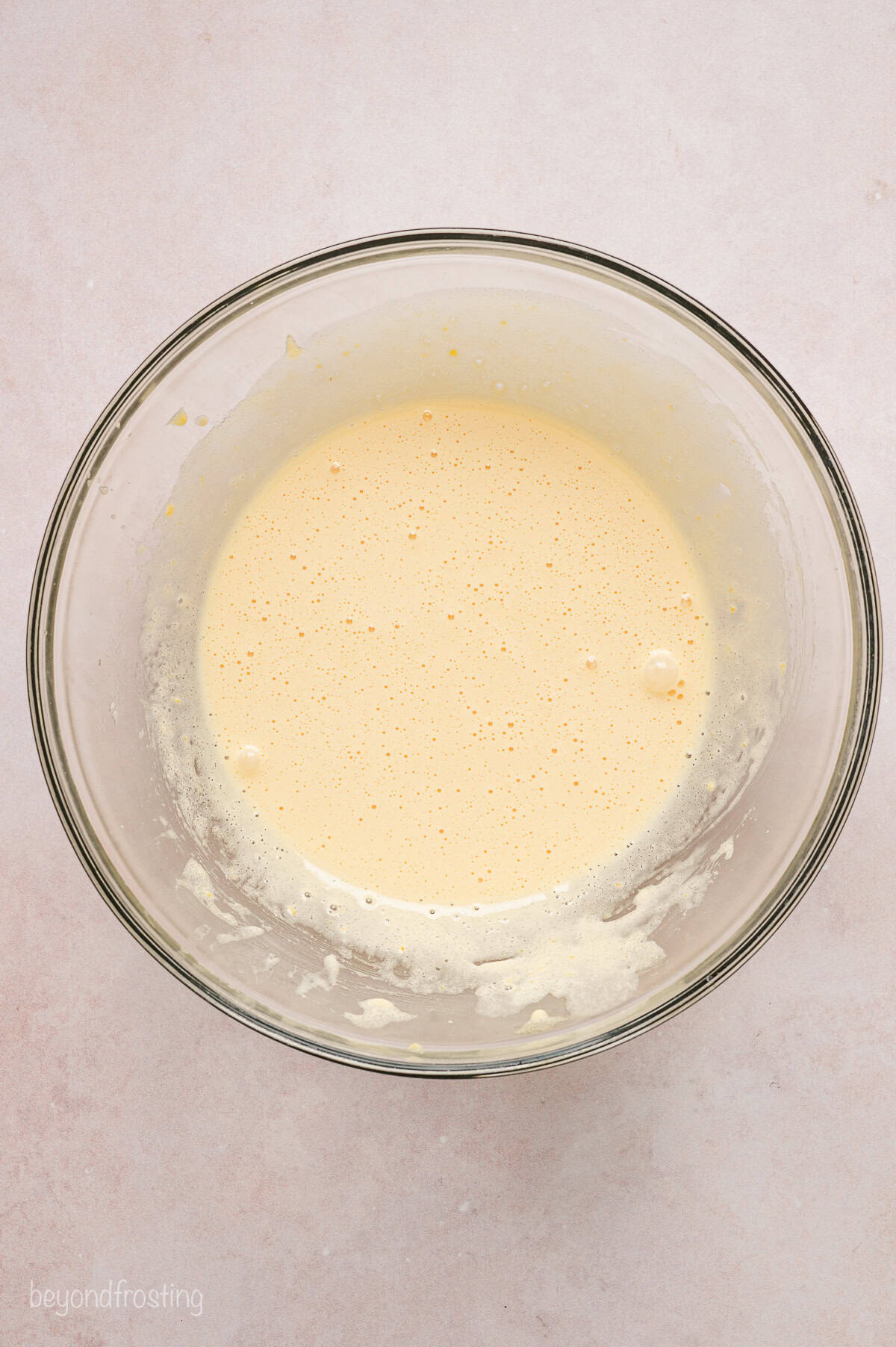 Wet cake batter ingredients in a glass bowl.