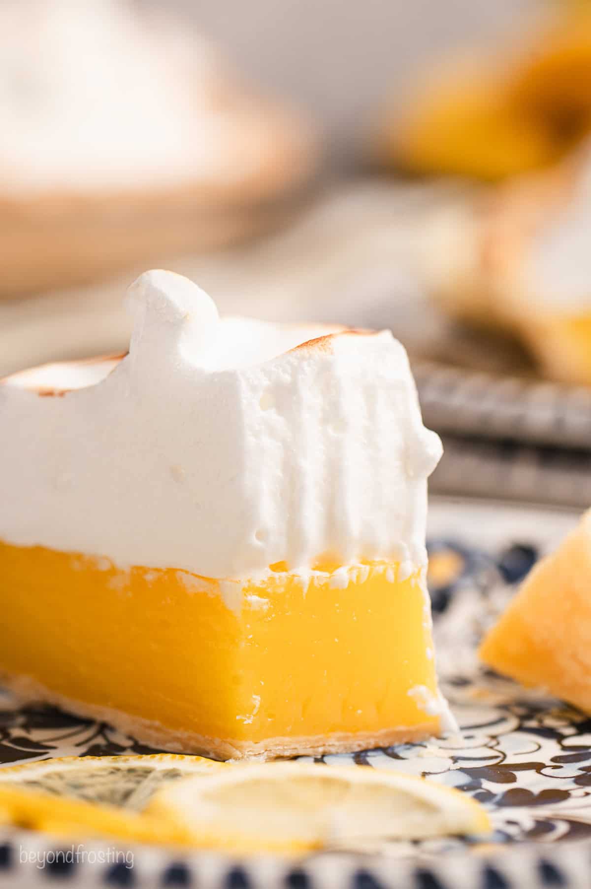 Close up of a slice of lemon meringue pie with a forkful missing from the tip.