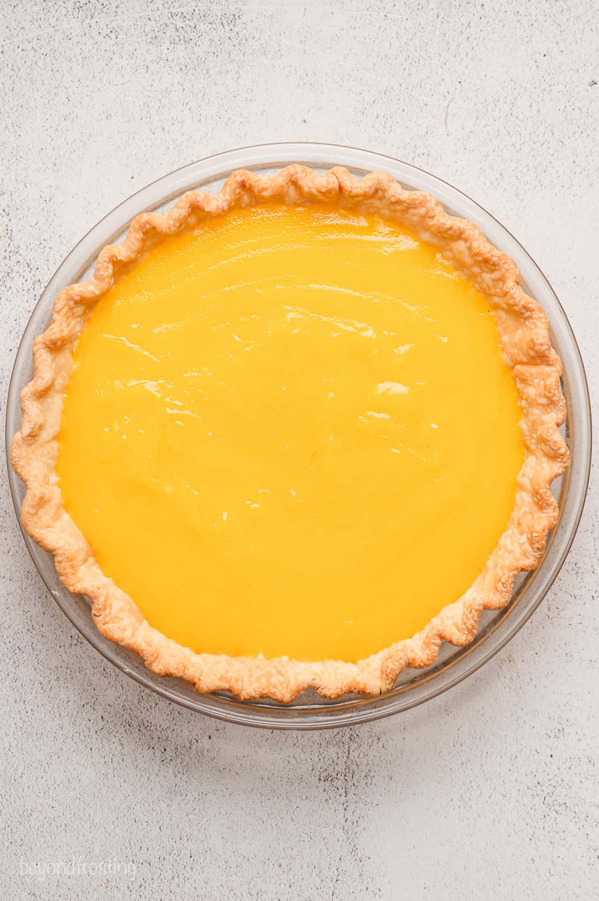 Overhead view of lemon meringue pie filling in a pie crust.