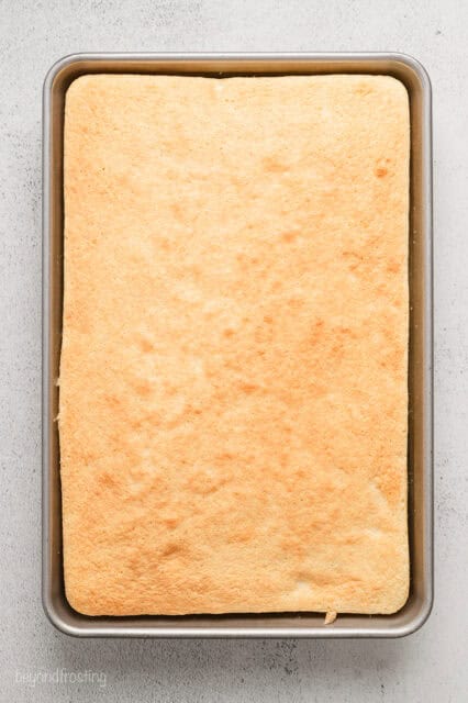 Baked vanilla cake in a large rectangular baking pan.