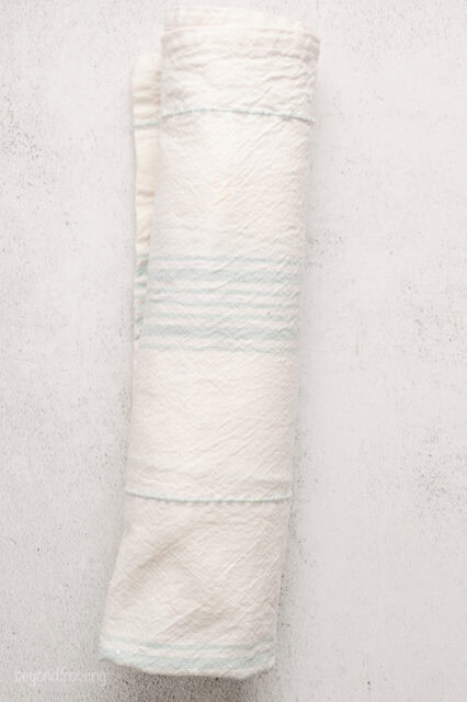 Vanilla cake rolled up inside a clean dish towel.