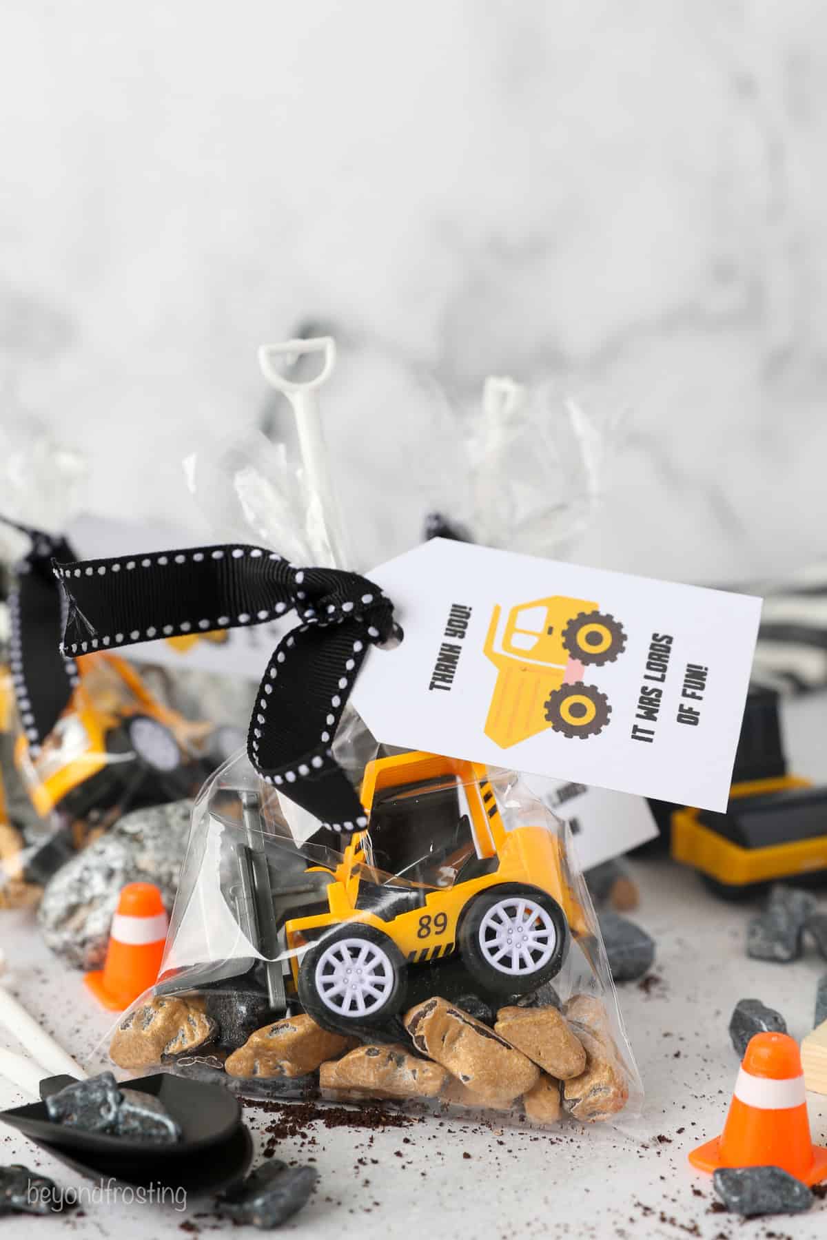 A cellophane baggie filled with construction party favors on a countertop.