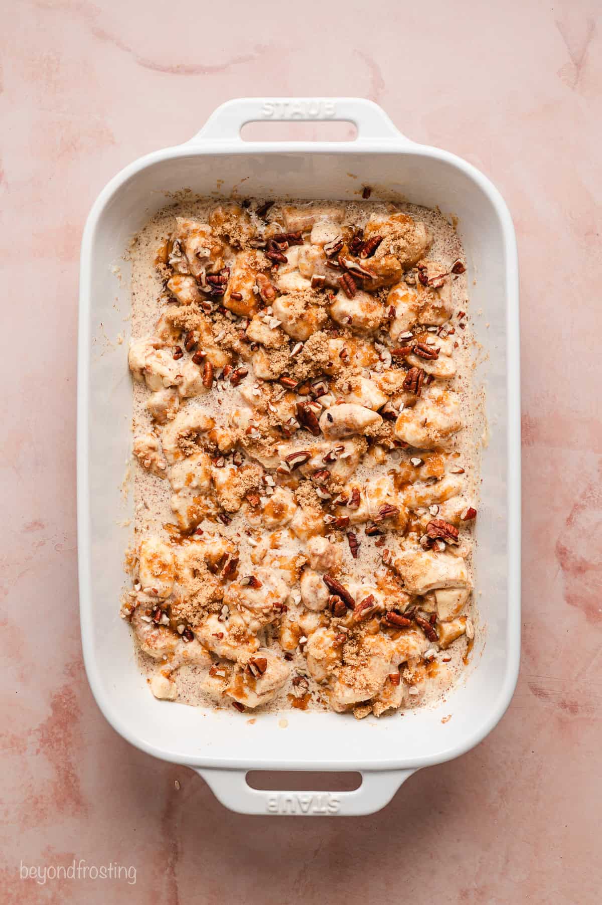 Cinnamon roll pieces soaked in custard in a baking dish.