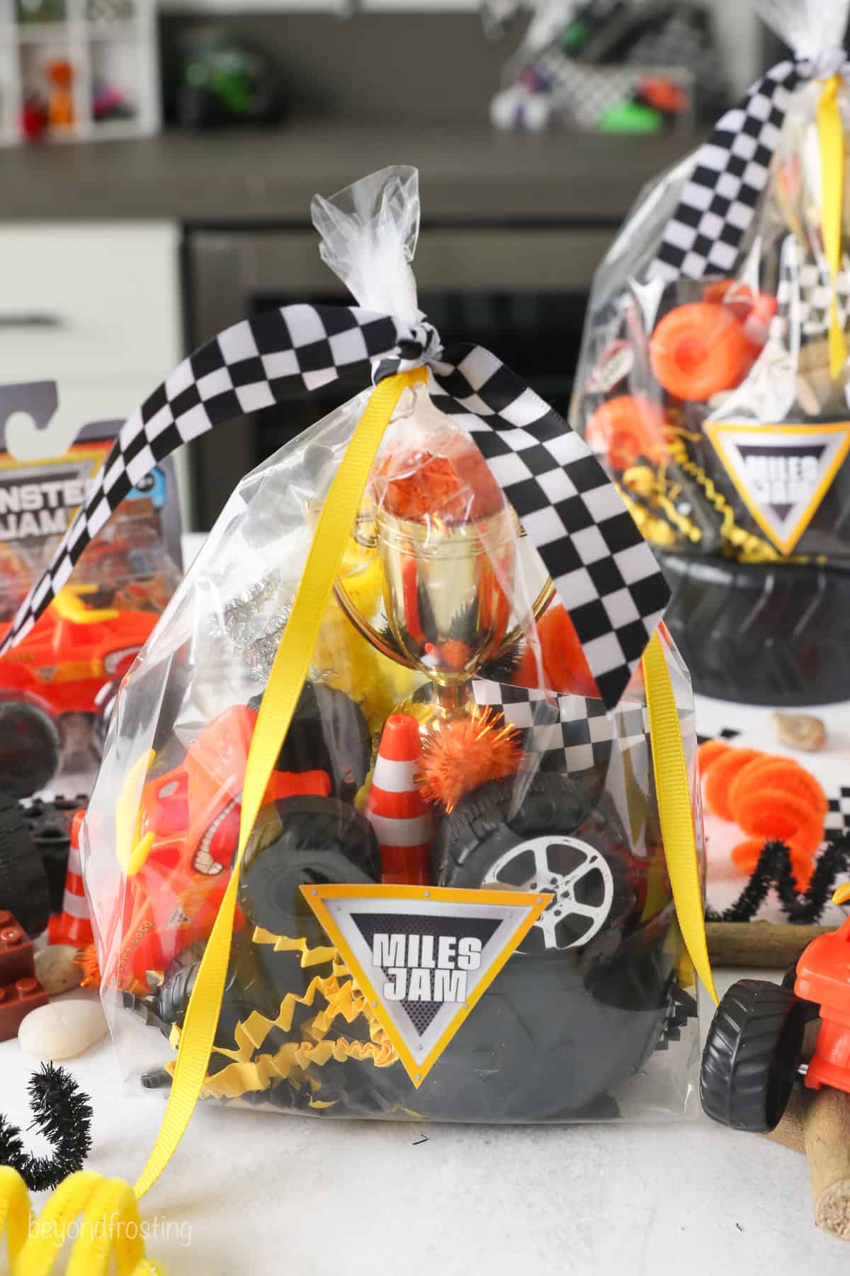 A Monster Jam play dough kit wrapped inside cellophane tied with a checkered ribbon.