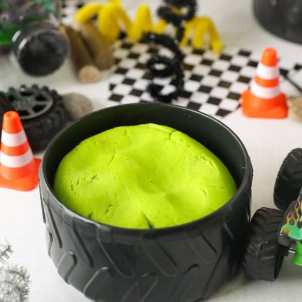 Electric green playdough inside a plastic tire bowl.