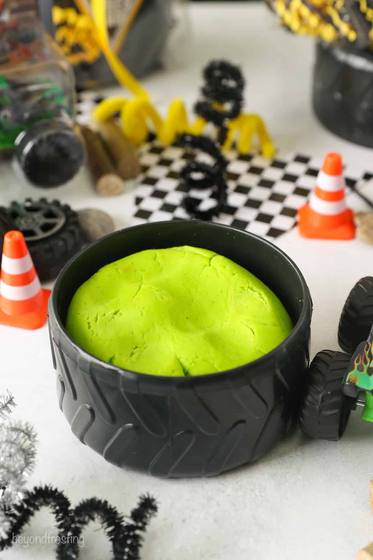 Electric green playdough inside a plastic tire bowl.
