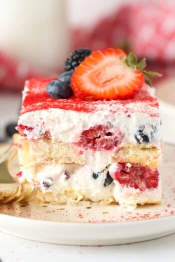 A close up of a slice of layered Berry Tiramisu with 2 forks on a. plate.