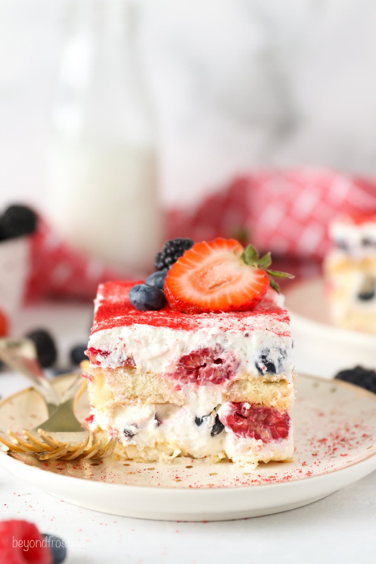 A close up of layered Berry Tiramisu with 2 forks on a. plate