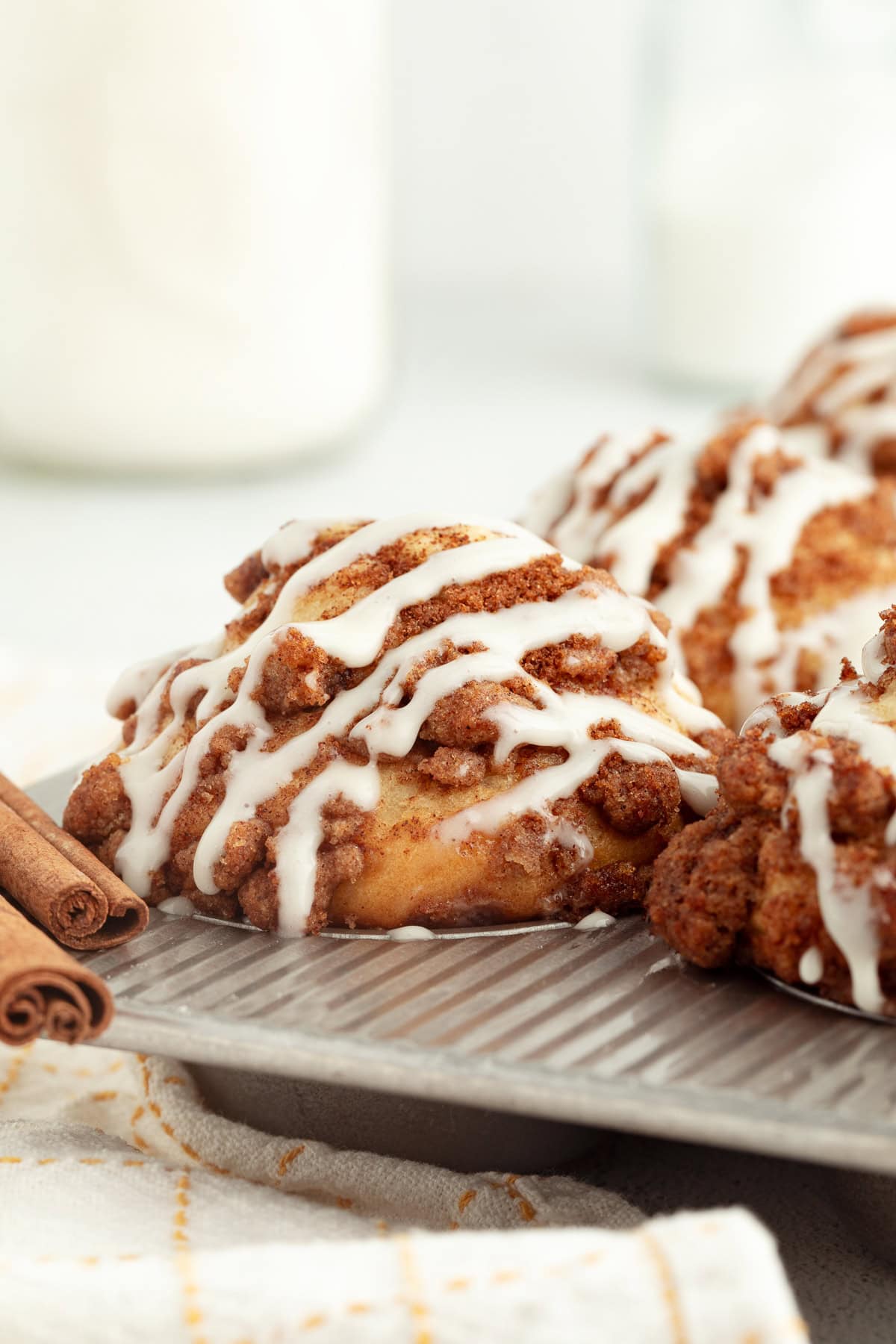 Coffee cake muffins topped with glaze inside a muffin pan.
