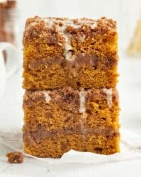 Two glazed slices of pumpkin coffee cake stacked on top of one another.