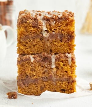 Two glazed slices of pumpkin coffee cake stacked on top of one another.