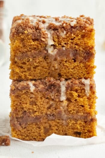 Two glazed slices of pumpkin coffee cake stacked on top of one another.