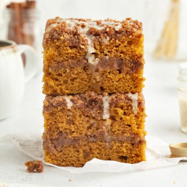 Two glazed slices of pumpkin coffee cake stacked on top of one another.