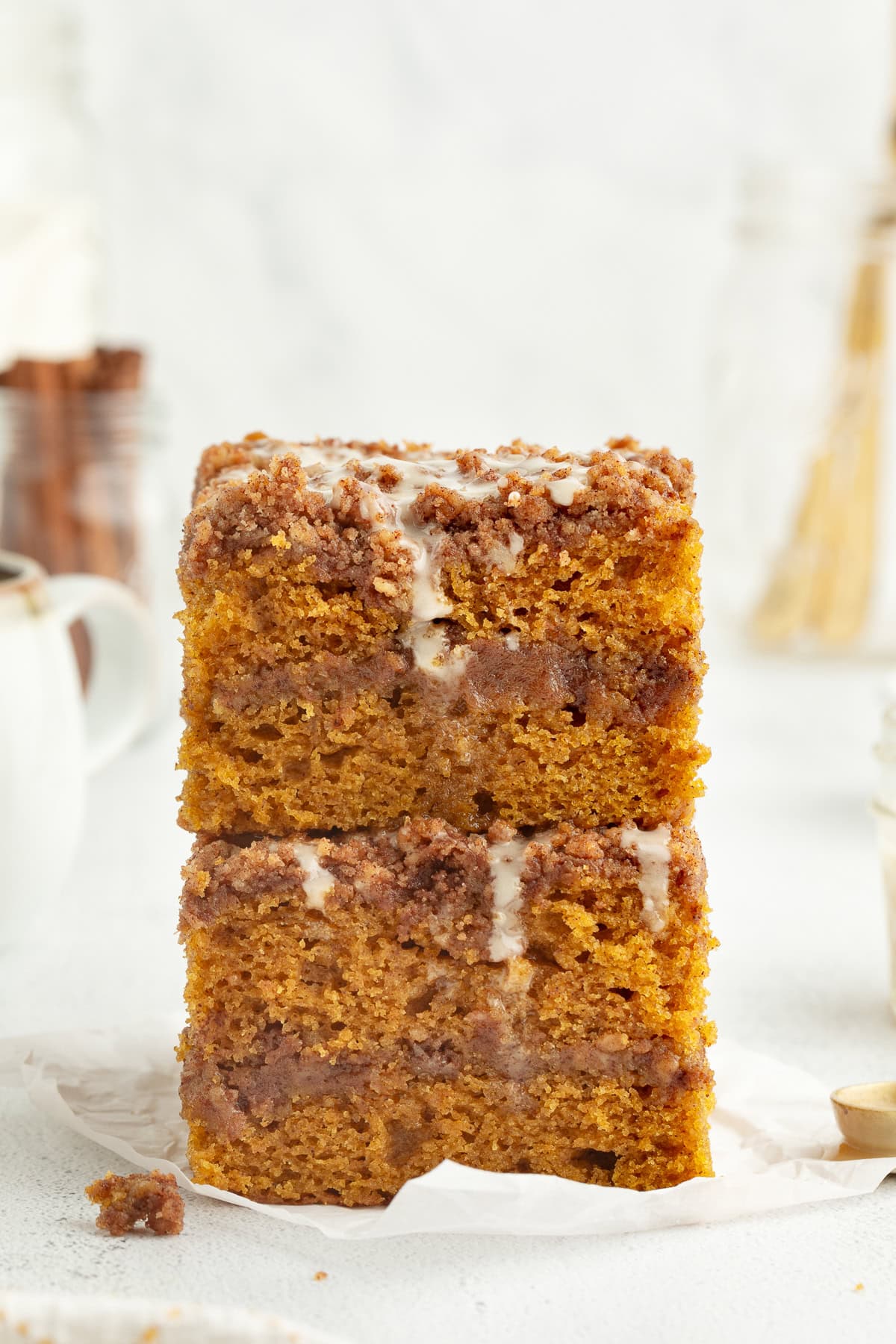 Two glazed slices of pumpkin coffee cake stacked on top of one another.