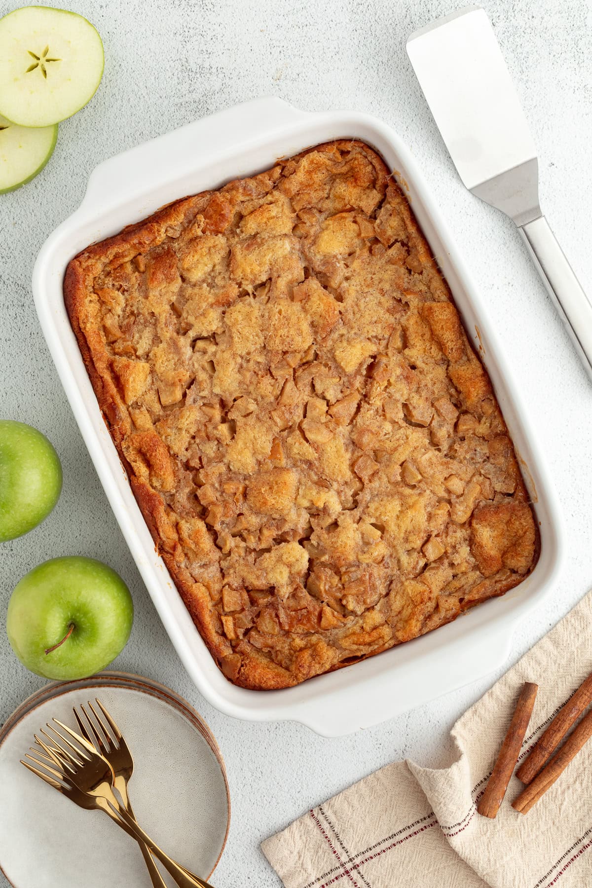 Overhead view of baked apple bread pudding in a ceramic casserole dish.