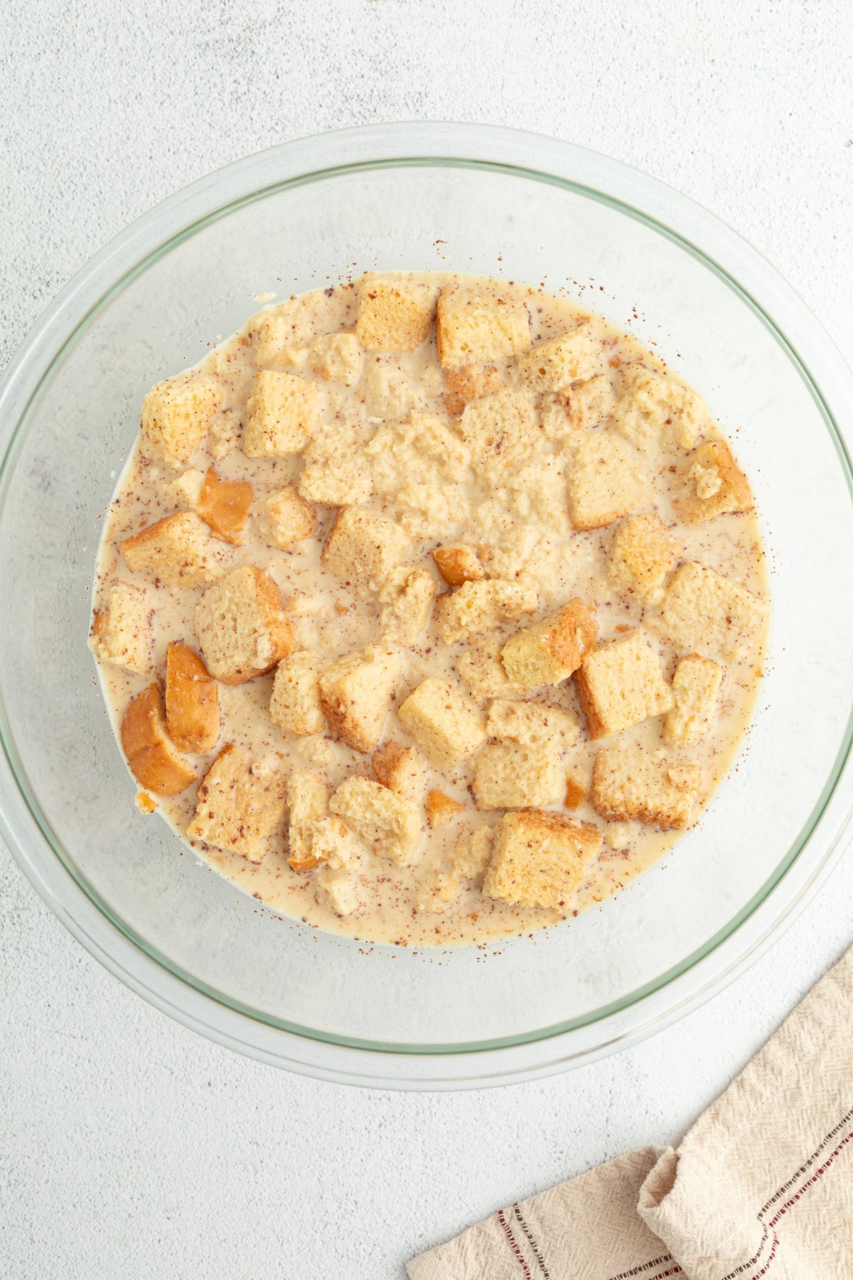 Bread soaking in a bowl with vanilla custard.