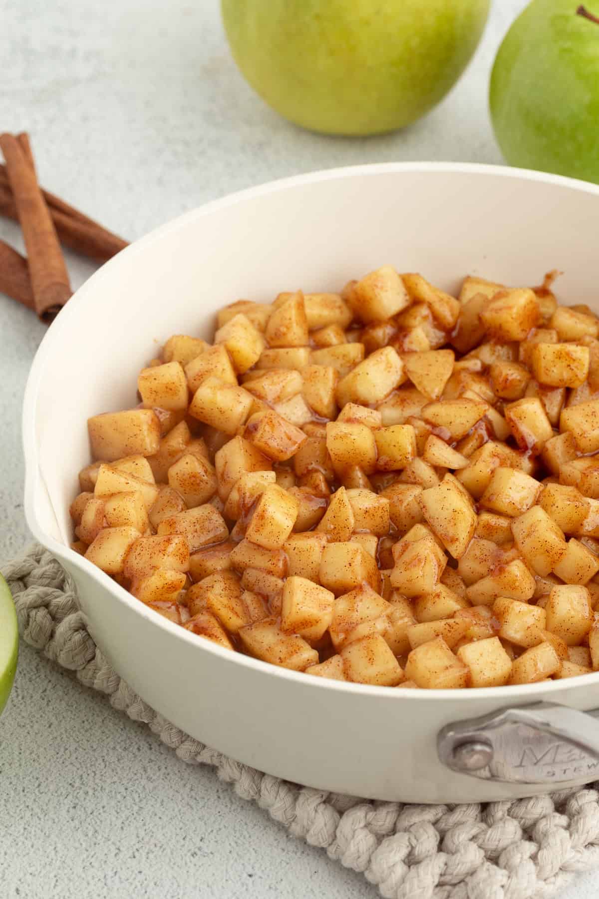 These apple pie egg rolls are golden, crispy egg roll wrappers bursting with homemade apple pie filling. Make them in the oven or air fryer! Homemade apple pie filling in a skillet.