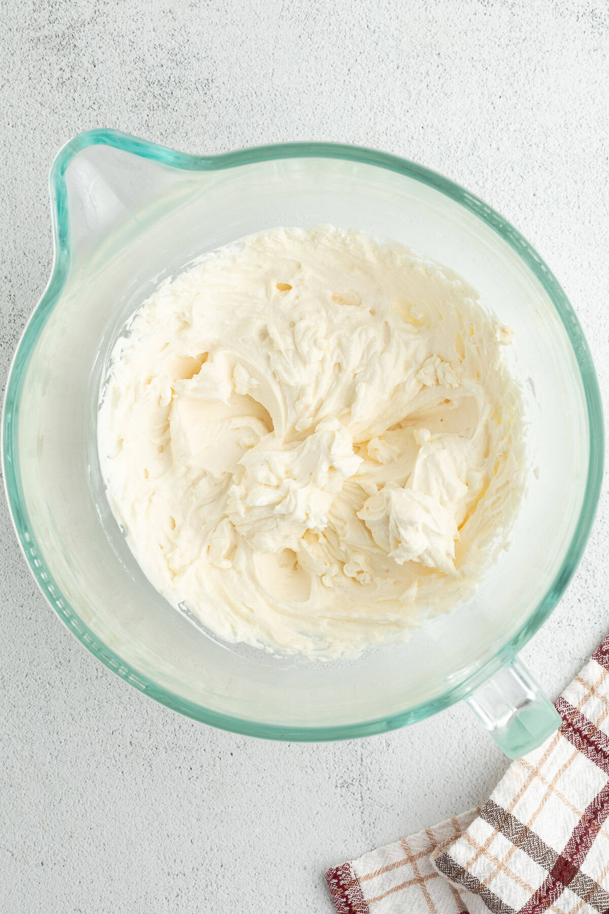 Mascarpone frosting in a glass mixing bowl.