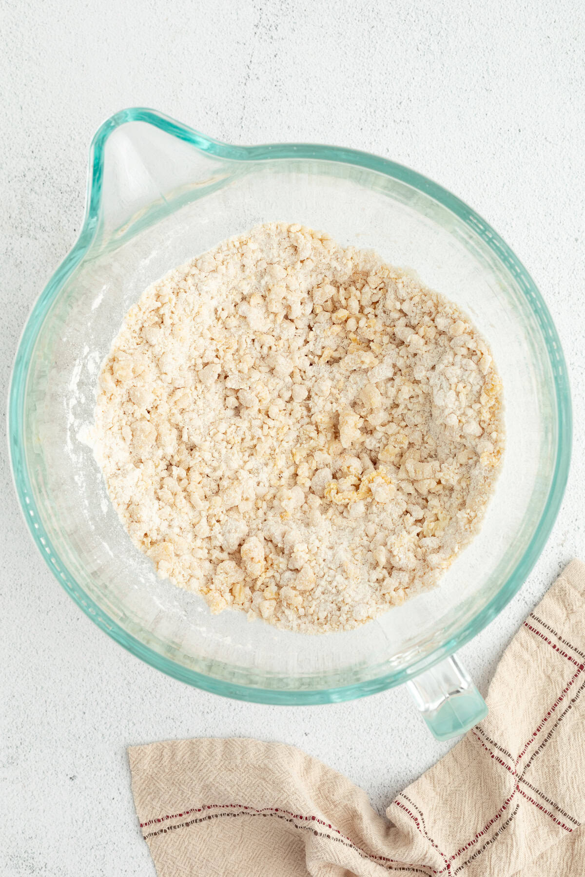 Homemade apple cinnamon rolls are golden-baked with warm cinnamon apple filling and topped with creamy brown butter cream cheese frosting. Cinnamon roll dough ingredients combined in a bowl.