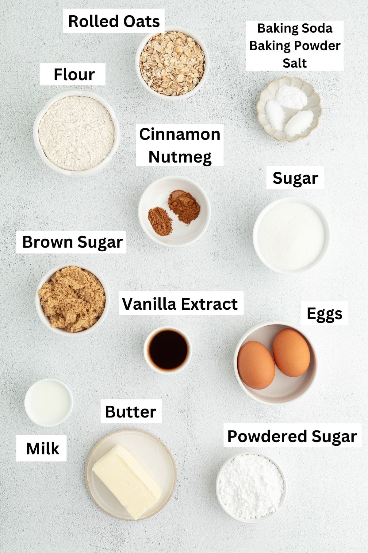 These old-fashioned iced oatmeal cookies have soft middles, crispy edges, and plenty of brown sugar and cinnamon, topped with vanilla icing. Iced oatmeal cookies ingredients with text labels overlaying each ingredient.