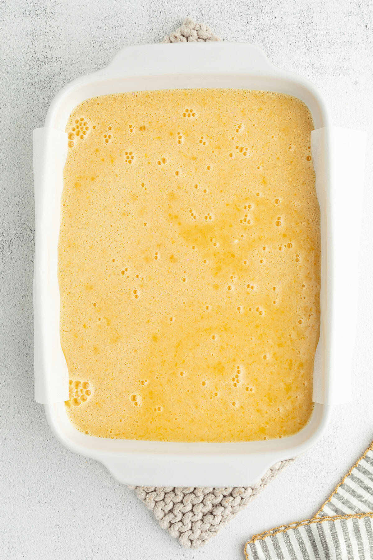 Make the best lemon bars that are perfectly baked with a soft, buttery shortbread crust and a sweet, tangy, creamy lemon curd filling. Lemon curd filling added to the crust in a baking dish.