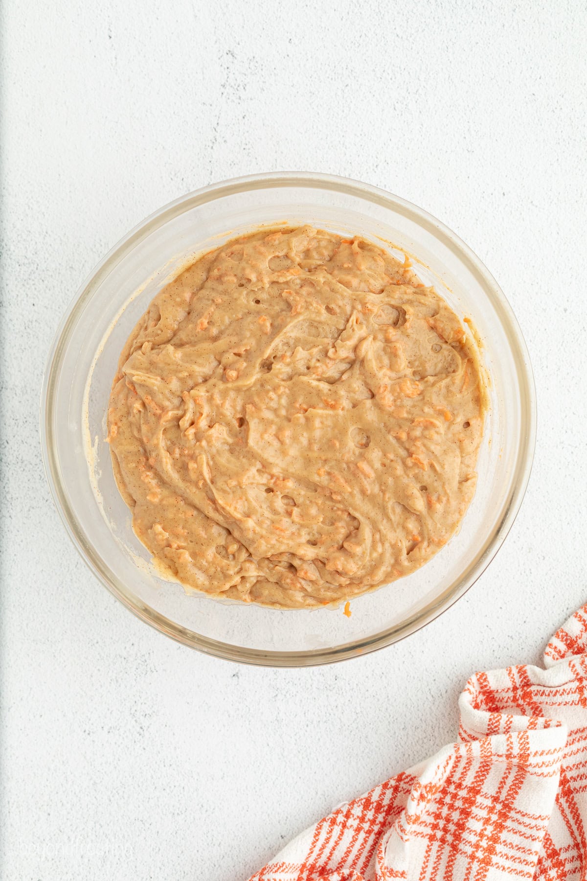 Sweet, moist carrot cake muffins are full of carrot cake flavor! They're easy to make, with the option to add a sweet cream cheese filling. Carrot muffin batter in a bowl.
