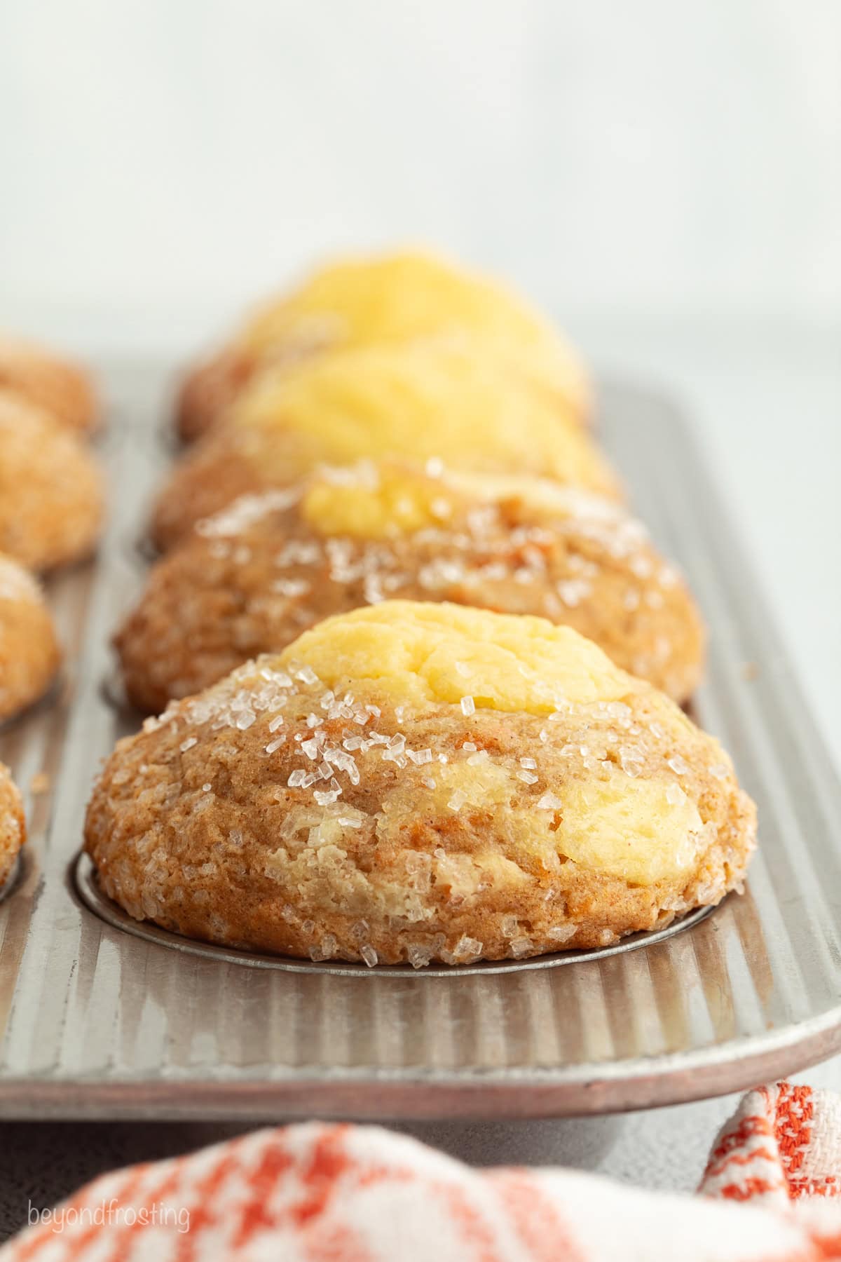 Sweet, moist carrot cake muffins are full of carrot cake flavor! They're easy to make, with the option to add a sweet cream cheese filling. Baked carrot cake muffins with cream cheese filling in a muffin pan.