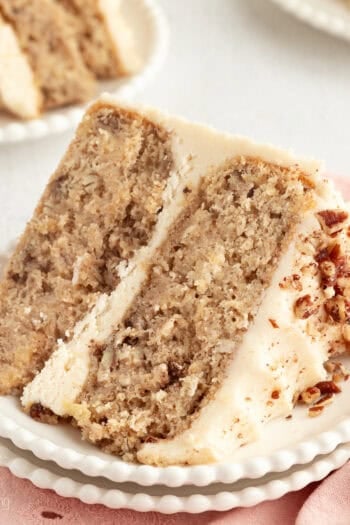 A slice of hummingbird cake with cream cheese frosting on a plate.