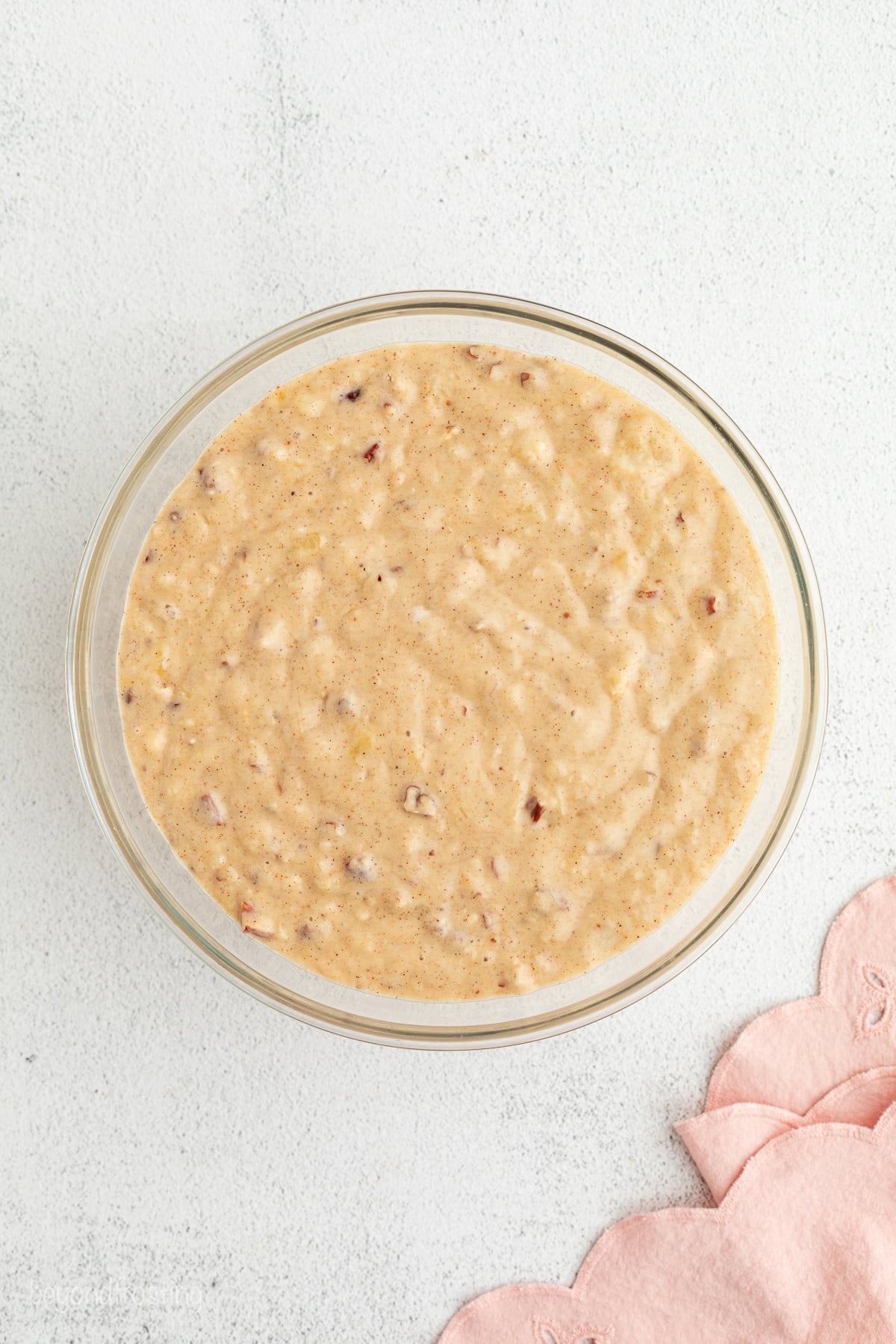 Hummingbird cake is a soft, spiced Southern layer cake with sweet banana, crushed pineapple, crunchy pecans, and cream cheese frosting. Hummingbird cake batter in a bowl.