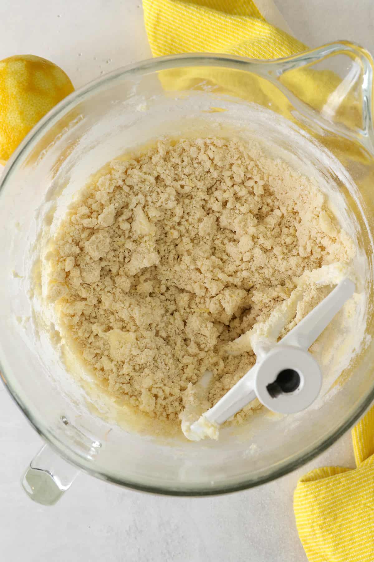 These slice-and-bake lemon shortbread cookies are crisp, buttery, and melt-in-your-mouth, rolled in sanding sugar for sweet, crunchy edges. Dry shortbread ingredients beaten into wet ingredients in a mixing bowl.