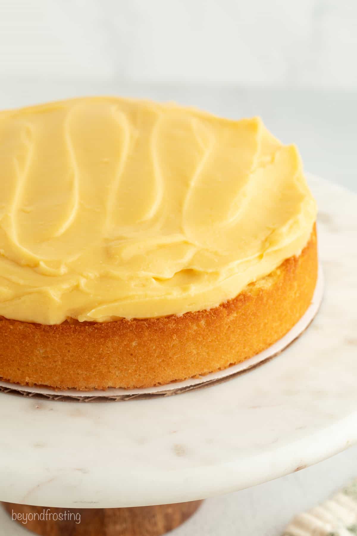 This homemade Boston cream pie is an airy sponge cake filled with pastry cxream and glazed with rich chocolate ganache, all made from scratch! Custard cream spread over the first cake layer for Boston cream pie.
