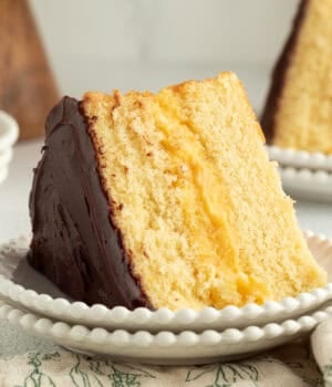 A slice of Boston cream pie with custard filling on a plate.