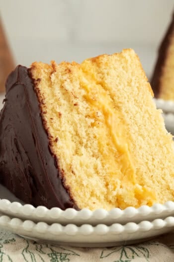 A slice of Boston cream pie with custard filling on a plate.