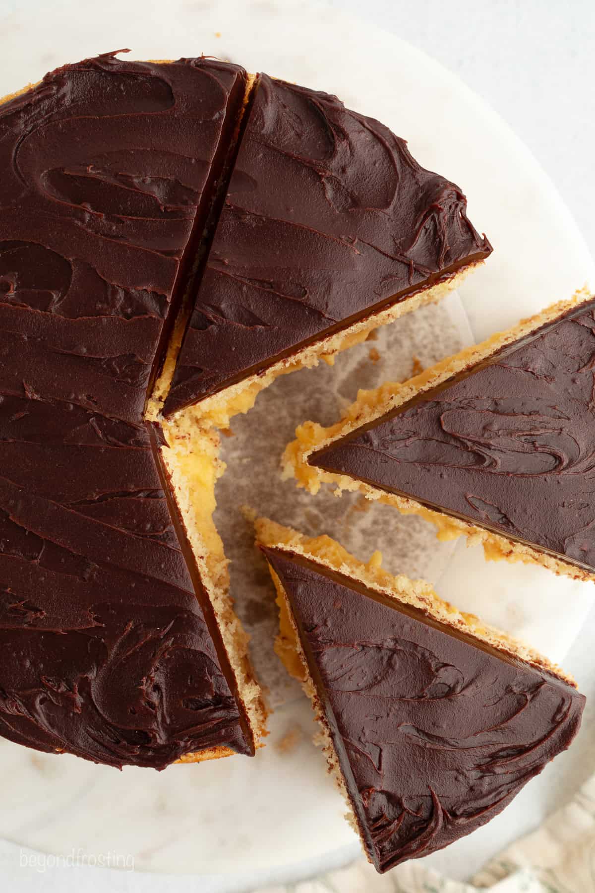 This homemade Boston cream pie is an airy sponge cake filled with pastry cxream and glazed with rich chocolate ganache, all made from scratch!
