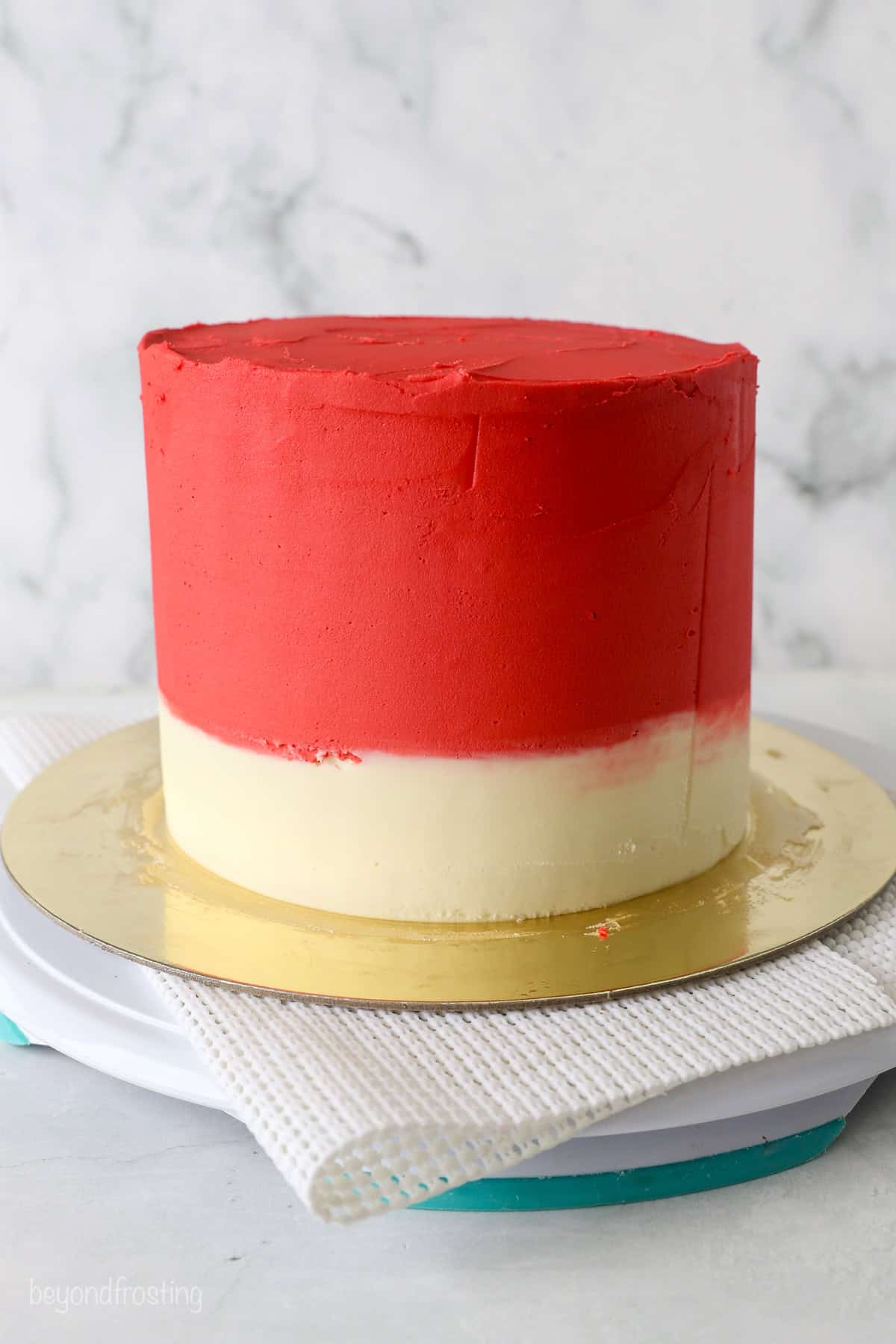 With racing-red frosting and just a little fondant, this Lightning McQueen layer cake is perfect for a kids’ Cars birthday party! A red and white frosted layer cake with the frosting smoothed out.