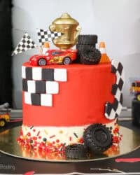 A Lightning McQueen cake with racing themed decorations.