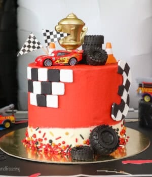 A Lightning McQueen cake with racing themed decorations.