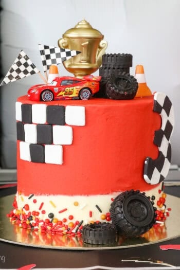 A Lightning McQueen cake with racing themed decorations.