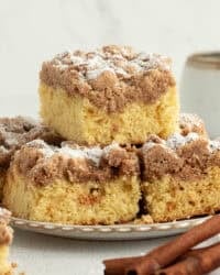 New York crumb cake sliced and stacked on plate.