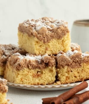 New York crumb cake sliced and stacked on plate.