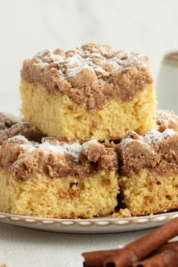 New York crumb cake sliced and stacked on plate.