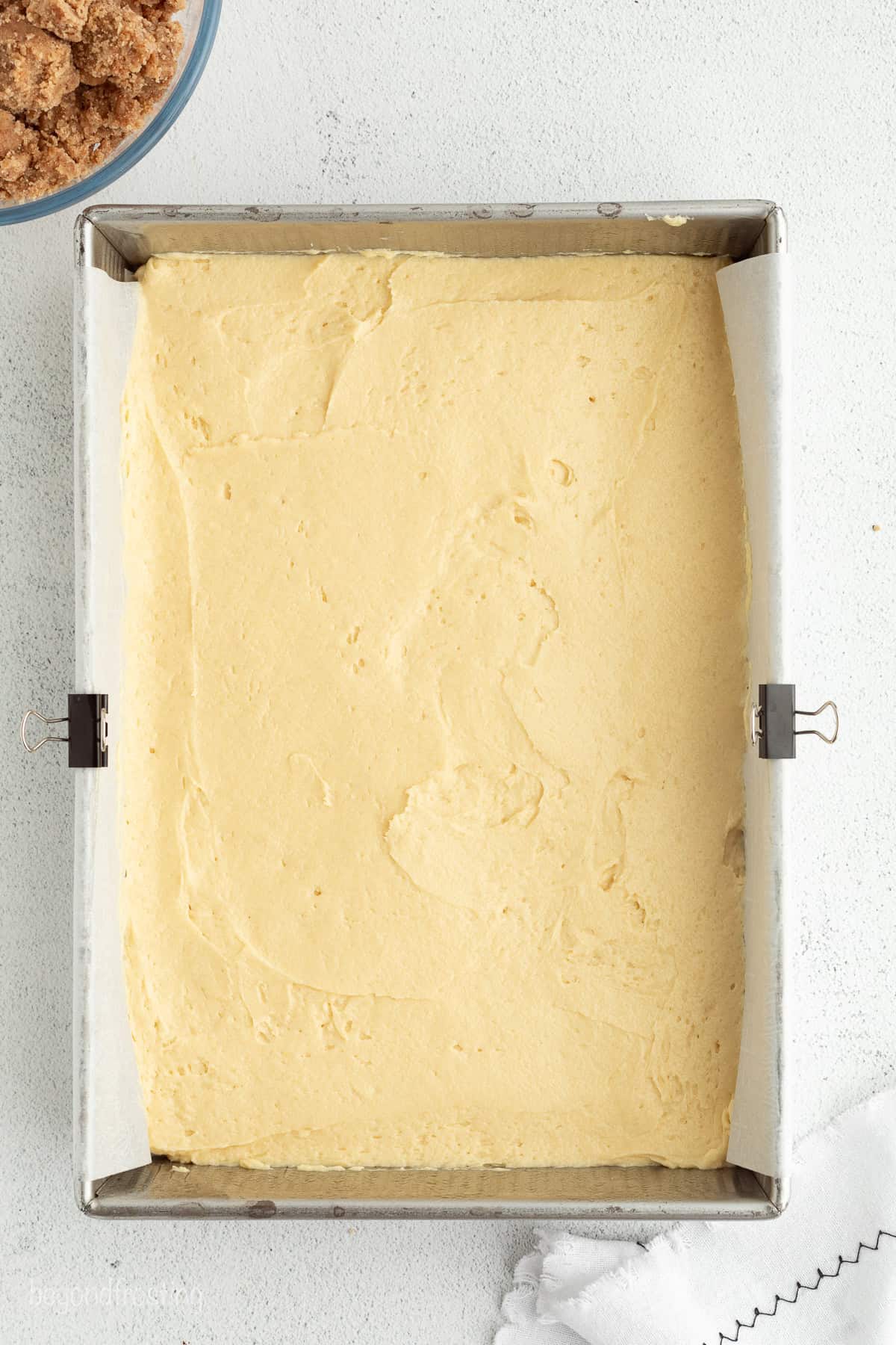 This New York crumb cake is tender and buttery, piled high with a thick brown sugar cinnamon streusel that’s almost as thick as the cake. Crumb cake batter spread inside a lined baking pan.