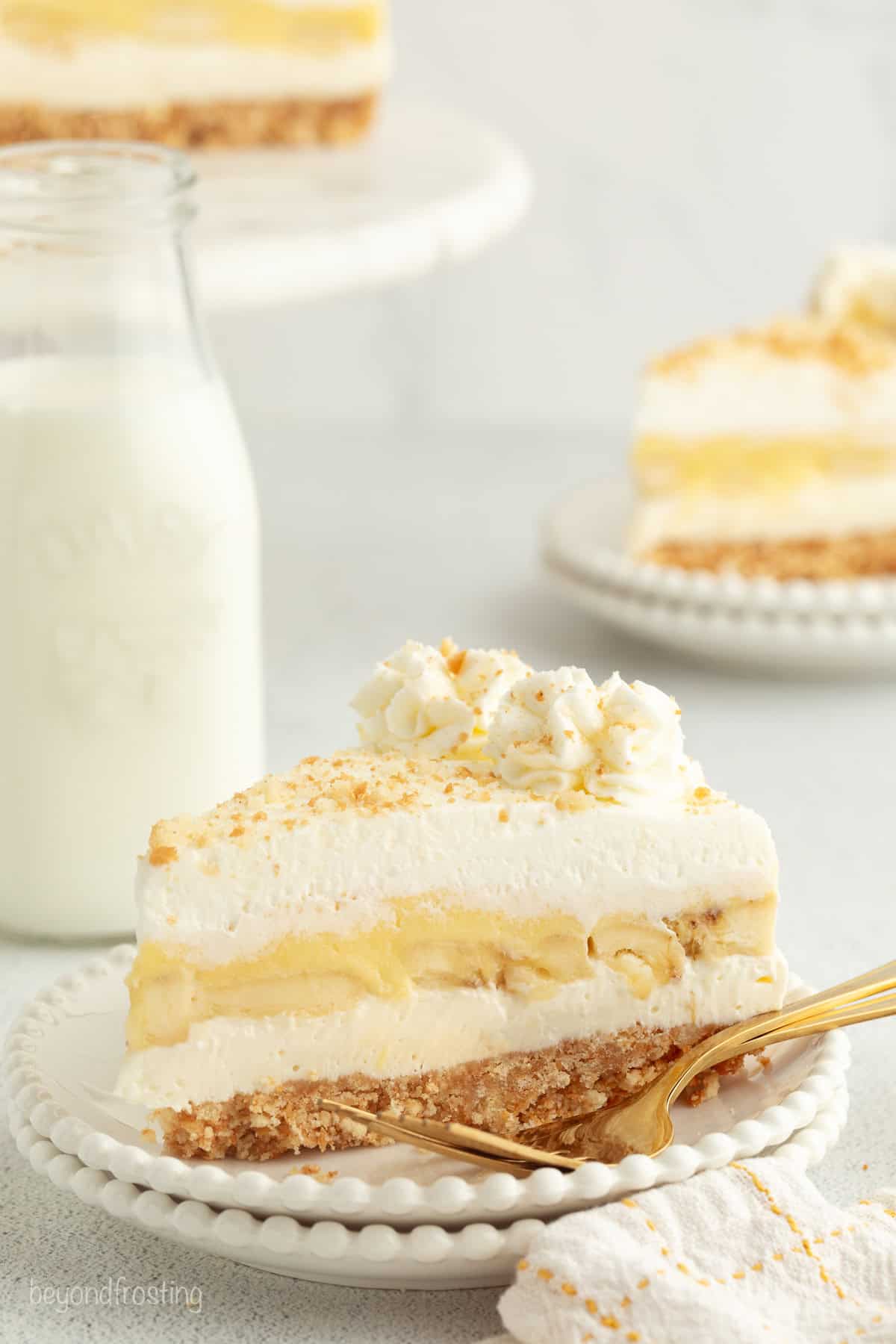 Make the best no-bake banana pudding cheesecake with creamy cheesecake filling, fresh banana slices, homemade pudding, and whipped cream. A slice of no-bake banana pudding cheesecake topped with whipped cream and Nilla wafer crumbs on a plate.