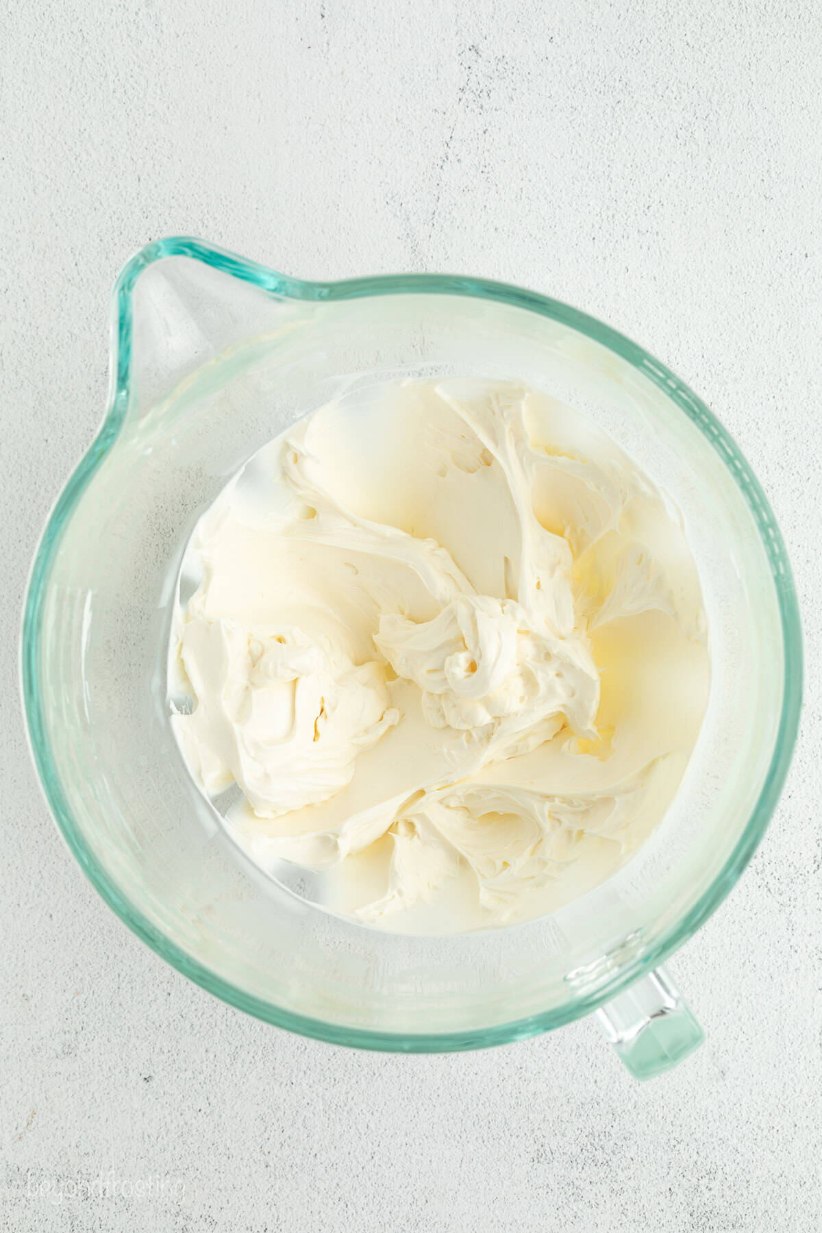 Make the best no-bake banana pudding cheesecake with creamy cheesecake filling, fresh banana slices, homemade pudding, and whipped cream. Cheesecake filling whipped in a glass bowl.