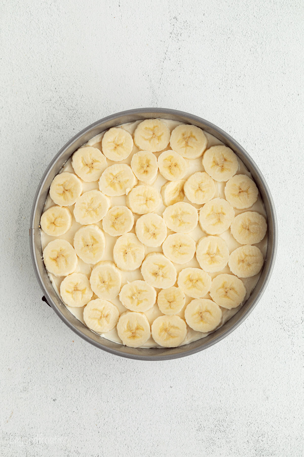 Make the best no-bake banana pudding cheesecake with creamy cheesecake filling, fresh banana slices, homemade pudding, and whipped cream. Fresh banana slices layered over a no-bake cheesecake in a springform pan.